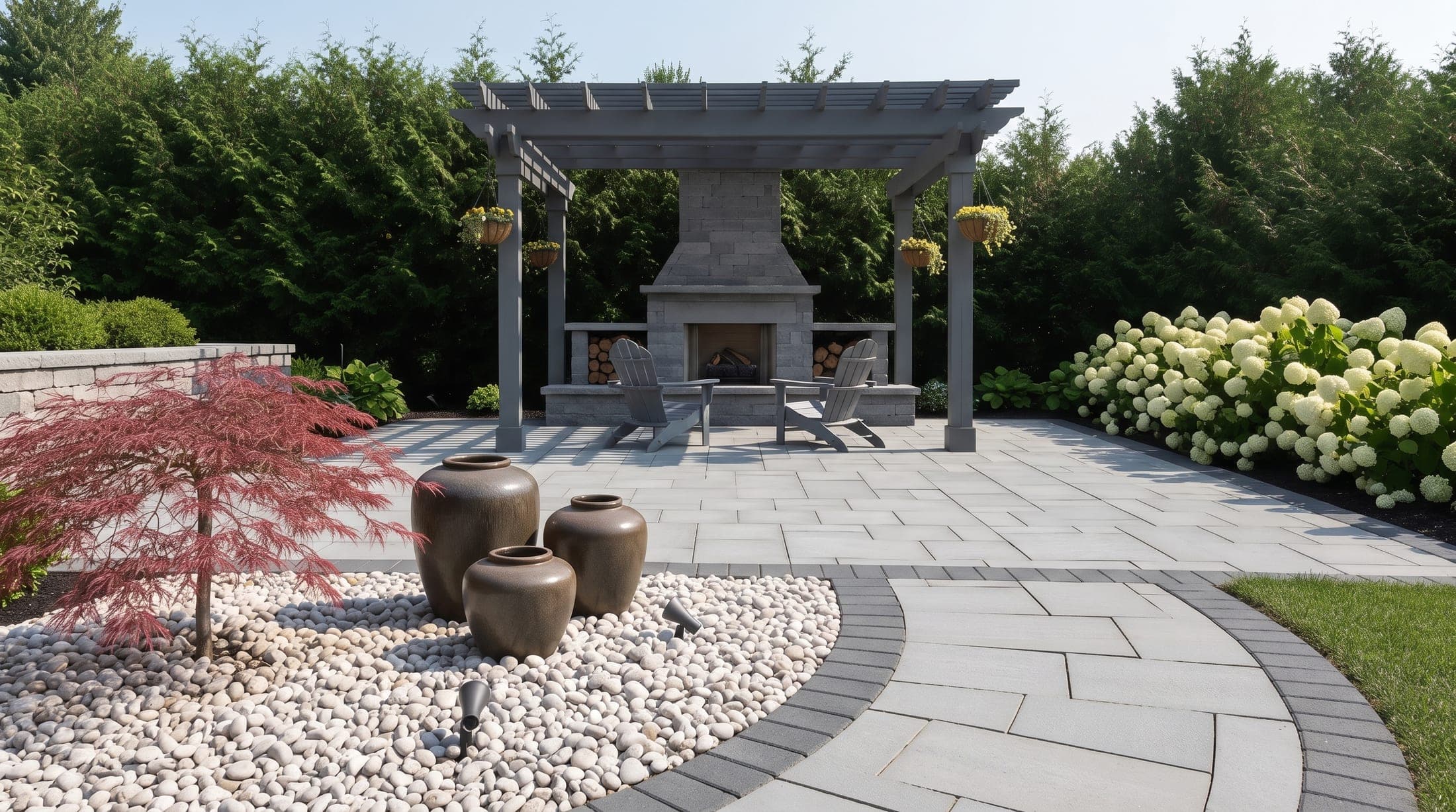 Paver patio with pergola and outdoor stone fireplace framed by hydrangeas