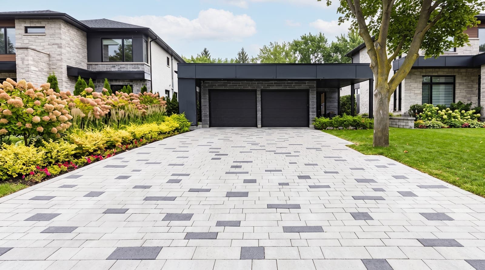 Light paver driveway with charcoal accents leading to a modern double garage